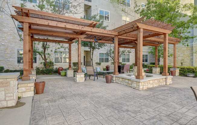 a patio with a pergola and a table and chairs