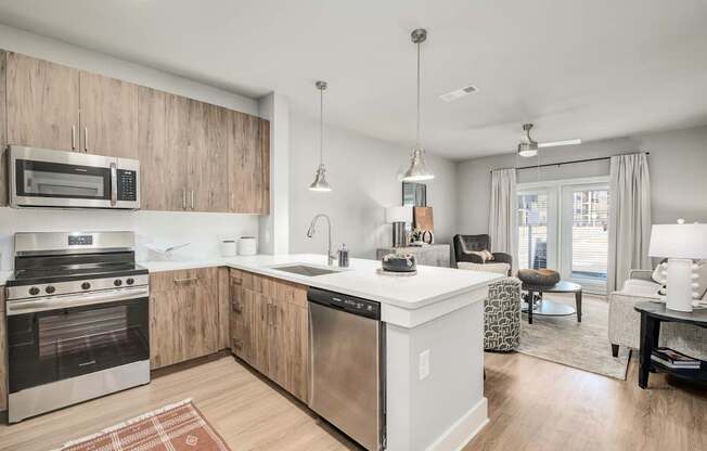 A modern kitchen with wooden cabinets and stainless steel appliances at The Ashton at East Park Apartments, Georgia, 30144