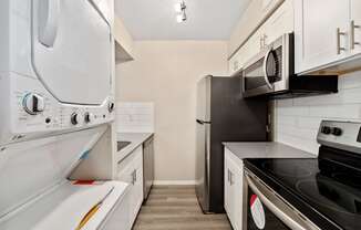 a kitchen with white cabinetry and black appliances