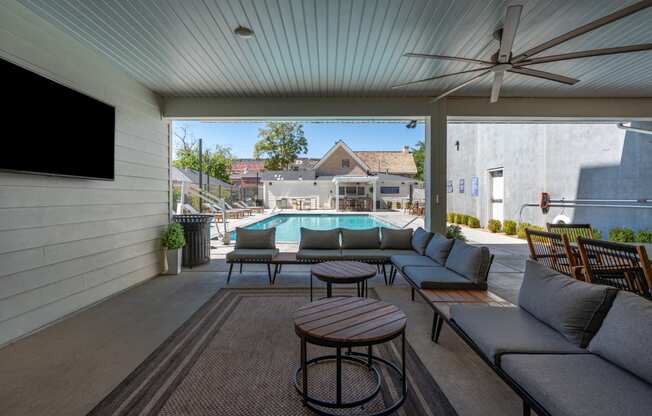 a patio with couches and chairs and a pool