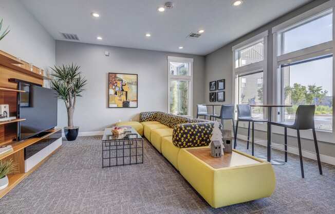 a living room with a yellow couch and a table with chairs