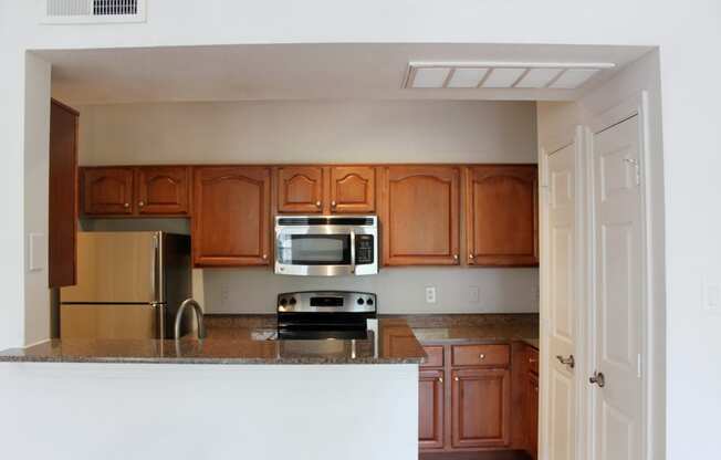 an empty kitchen with wooden cabinets and a counter top