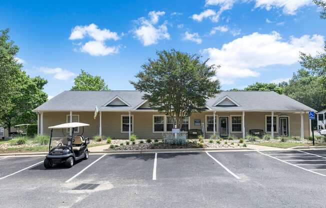 a clubhouse with a golf cart in the parking lot