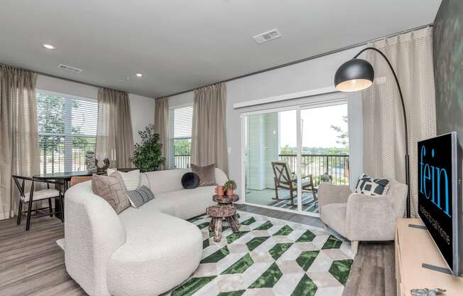 a living room with a couch and chairs and a tv