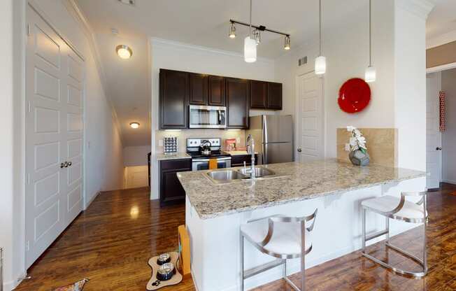 a kitchen with a large island with granite countertops