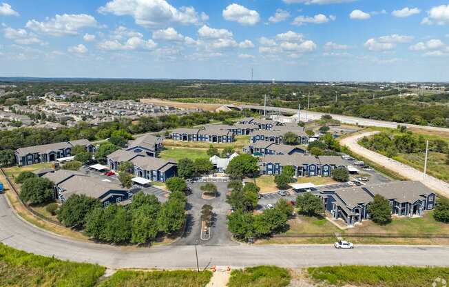 A large, modern building complex with a parking lot in front.