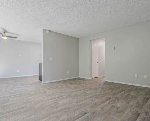 an empty living room with a hard wood floor at The Arches Apartments, California