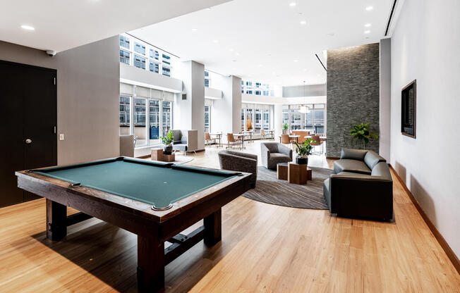 Entertainment lounge amenity space with comfy seating, billiards table, and televisions at 4545 Cent