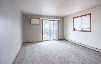 A room with a carpeted floor and a sliding glass door. Fargo, ND Westwood Estates