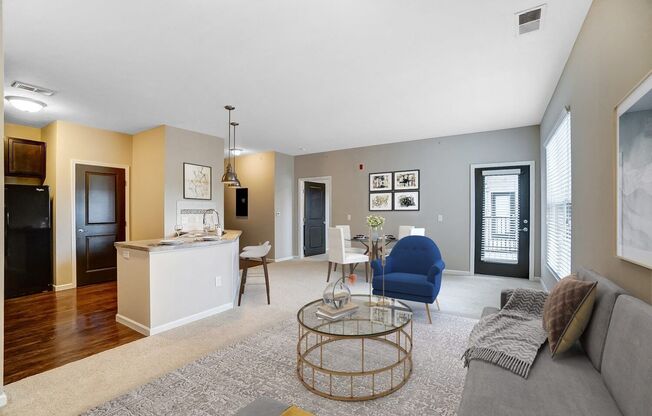 a living room and kitchen with a couch and a table