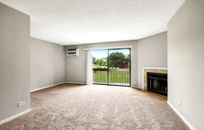 an empty living room with a fireplace and a balcony