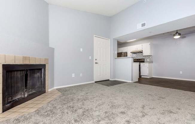 A living room with a fireplace and a carpeted floor.