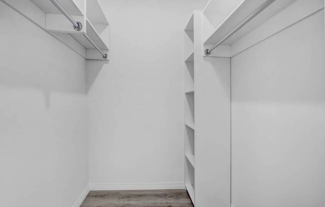 a room with white walls and a closet with shelves