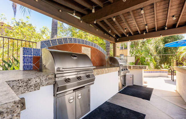 A stainless steel outdoor grill is on a patio.