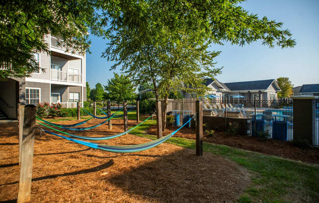 a playground with hammocks in front of an apartment building at The Shallowford, Chattanooga, TN, 37421