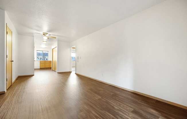 a living room with hardwood floors and white walls