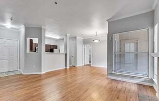 A spacious room with wooden floors and white walls.