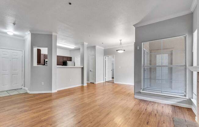 A spacious room with wooden floors and white walls.