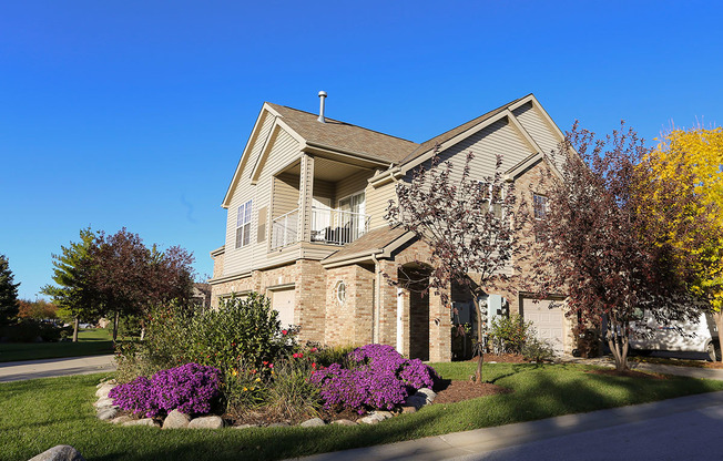 the front of a villa building with a yard with purple flowers