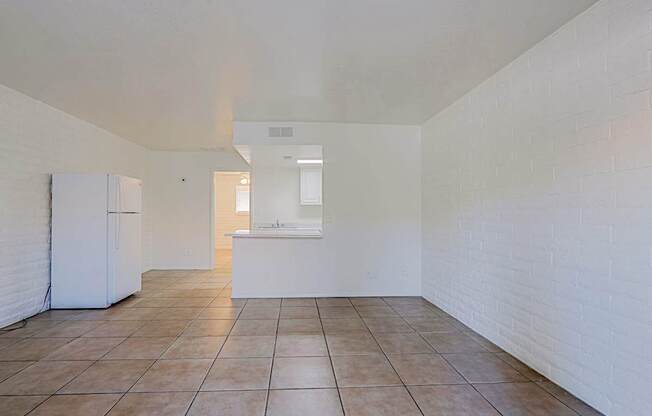 A kitchen area with a white refrigerator and a white countertop.