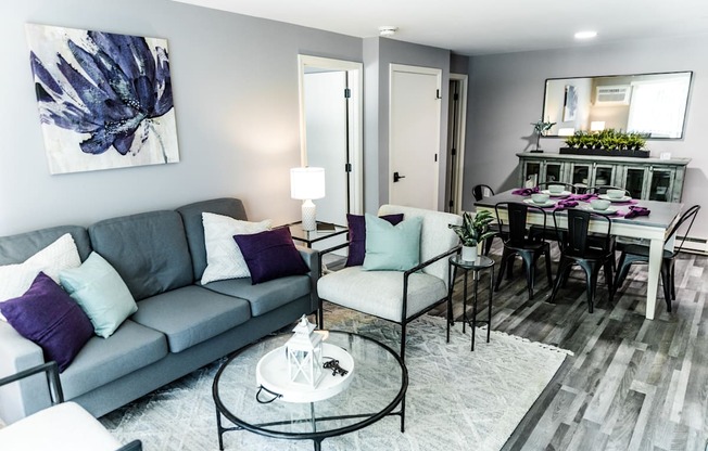a living room and dining room with a couch and chairs and a table with a chair and