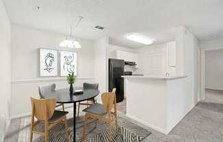 A dining room with a table and chairs.