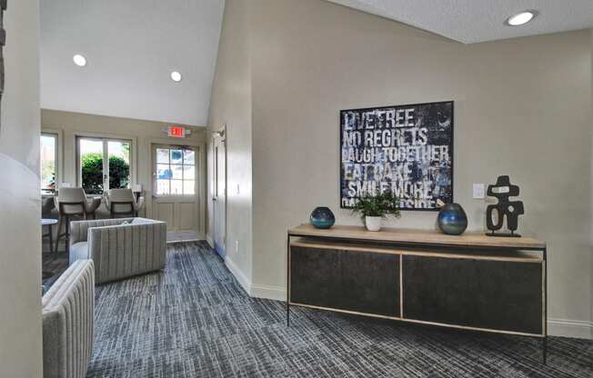 a lobby with couches and a table and a painting on the wall