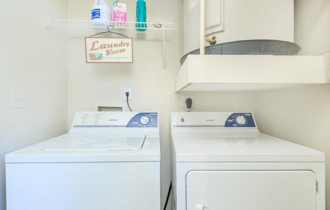 a white laundry room with two washes and a dryer