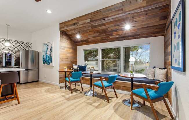 A kitchen with a wooden ceiling and a dining table with chairs.