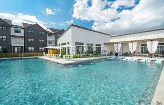 a swimming pool with lounge chairs and umbrellas in front of a building
