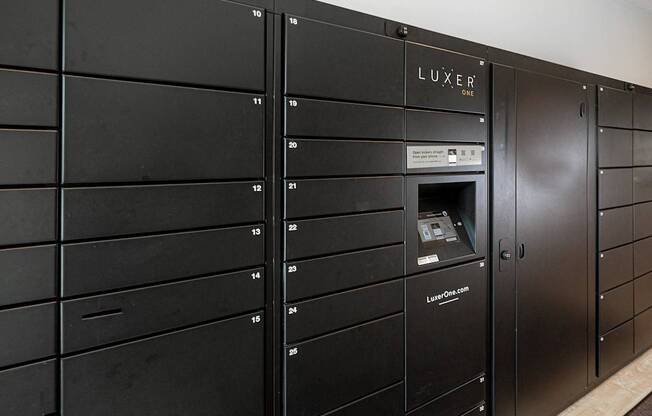 A row of black lockers with the word LUXER on the top of the doors.