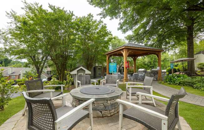 a patio with chairs and tables and a fire pit