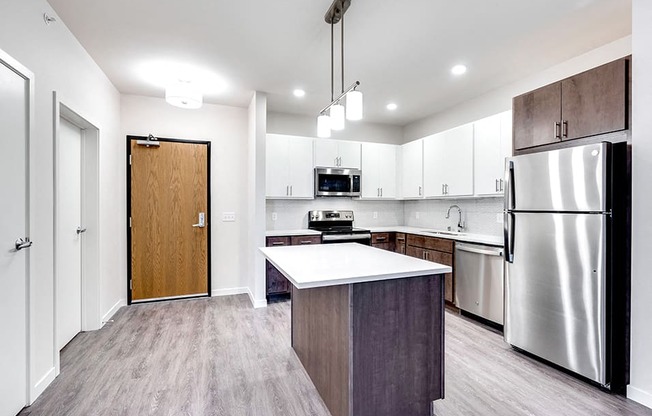 brightly lit apartment entryway and kitchen with island