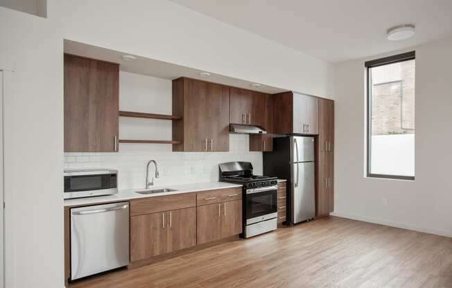 a kitchen with wooden cabinets and stainless steel appliances and a window