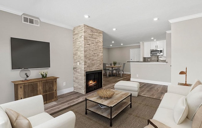 Living room with stone accented fireplace and mounted television.