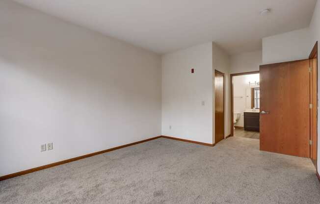 a living room with carpet and a door to a bathroom