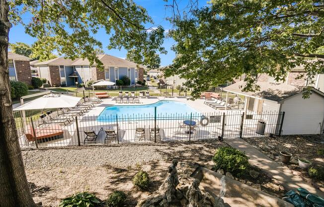 View of the poolside lounge area and landscaping at The Arbor in Blue Springs, Missouri