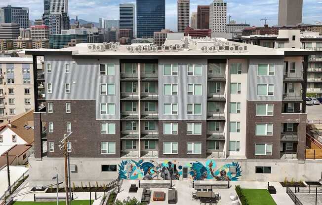A large building with a lot of windows and graffiti on the ground.