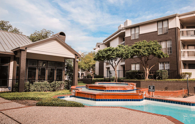 a fountain sits in front of an apartment building