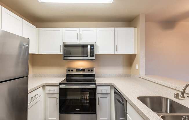 a kitchen with stainless steel appliances and white cabinets at THE MEADOWS, Santa Rosa