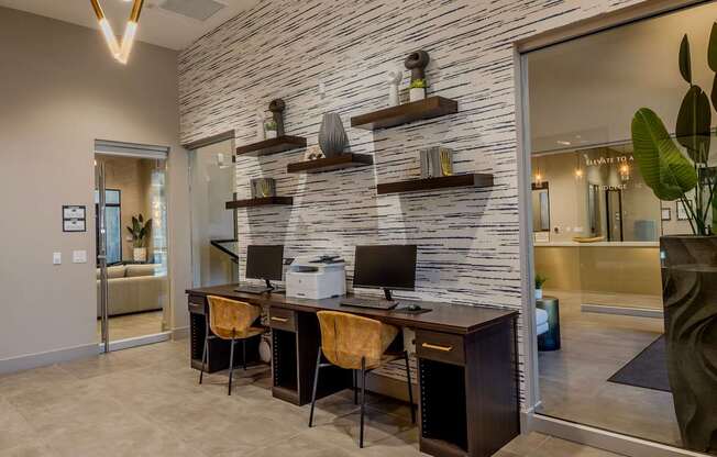Beautifully designed resident computer center with two computer stations with chairs, and wall decor.