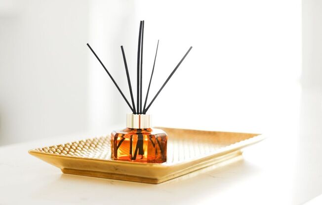 a diffuser sitting on a tray with a black reed diffuser on top of it