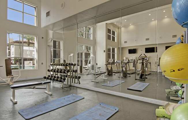 a fitness center with mirrors and exercise equipment