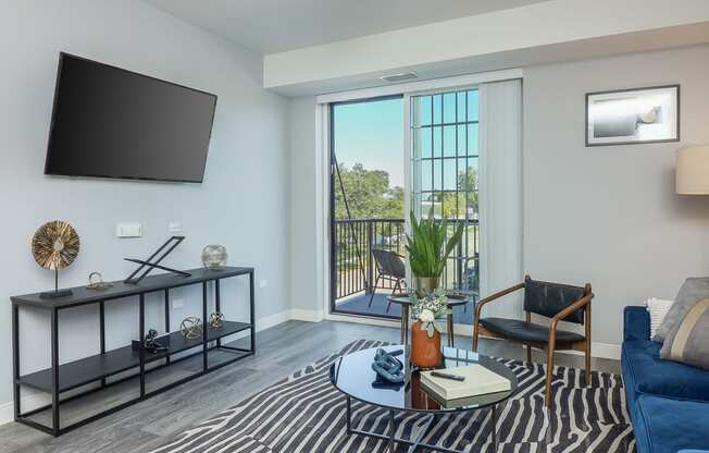 a living room with a blue couch and a coffee table and a television