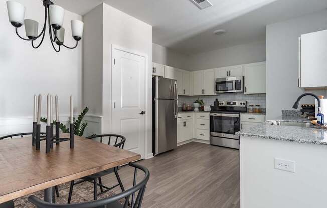 A modern kitchen with a wooden table and chairs.