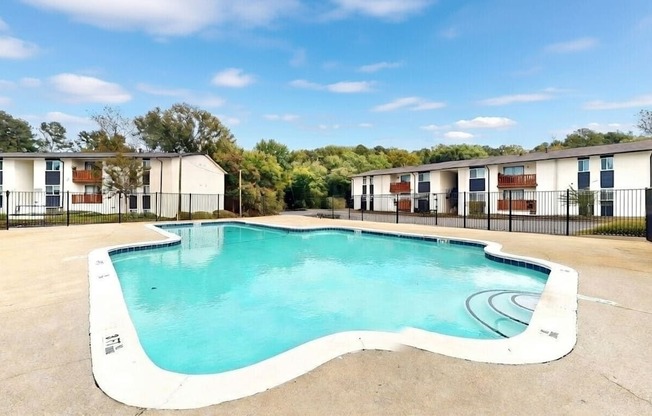 A swimming pool in front of apartment buildings.