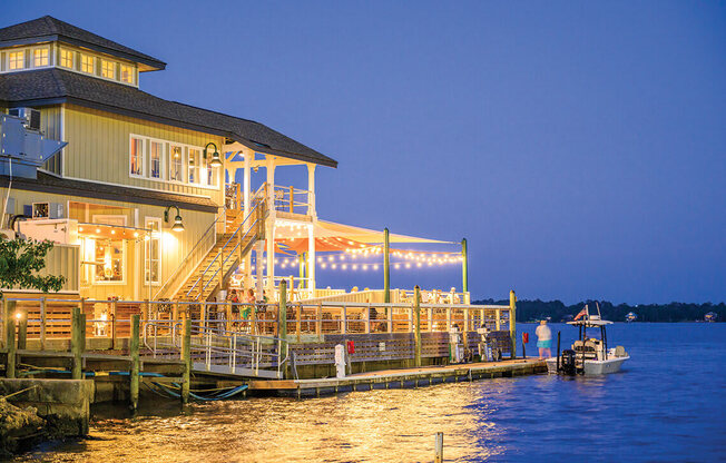 a restaurant on a dock on the water at night