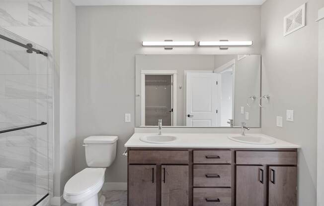 A bathroom with a white toilet, a sink, and a mirror.