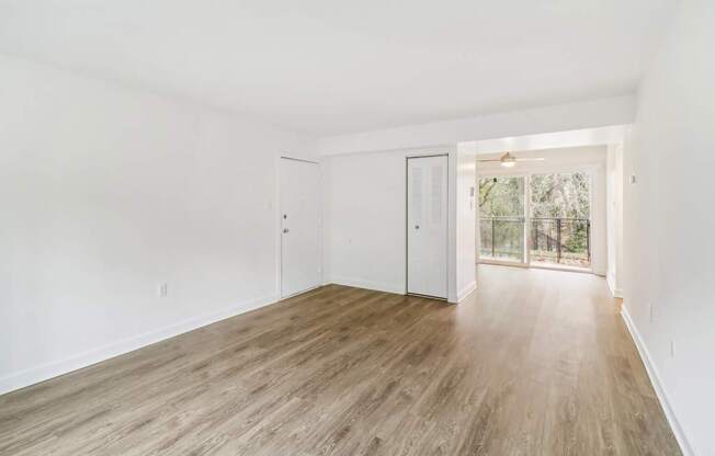 an empty living room with white walls and wood floors