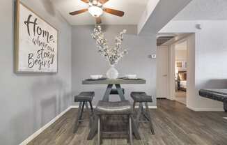 a dining area with a table and chairs and a ceiling fan